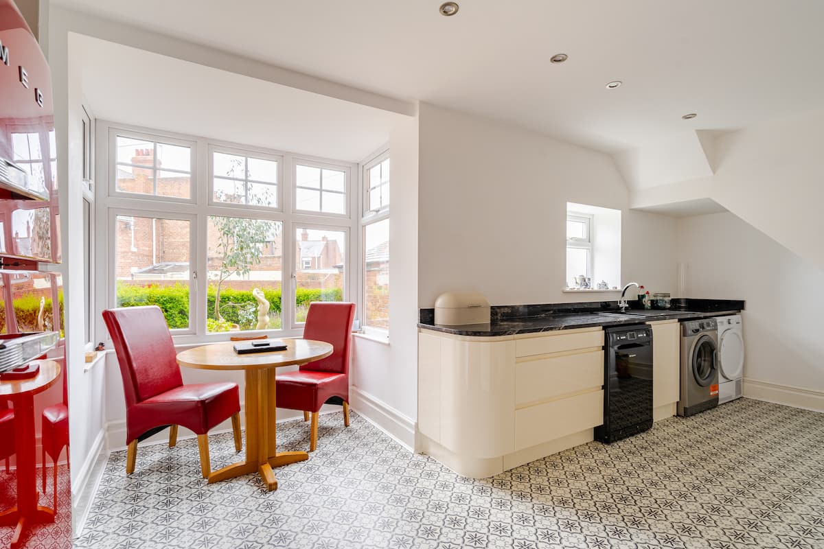 Kitchen dining nook with bay window and red chairs